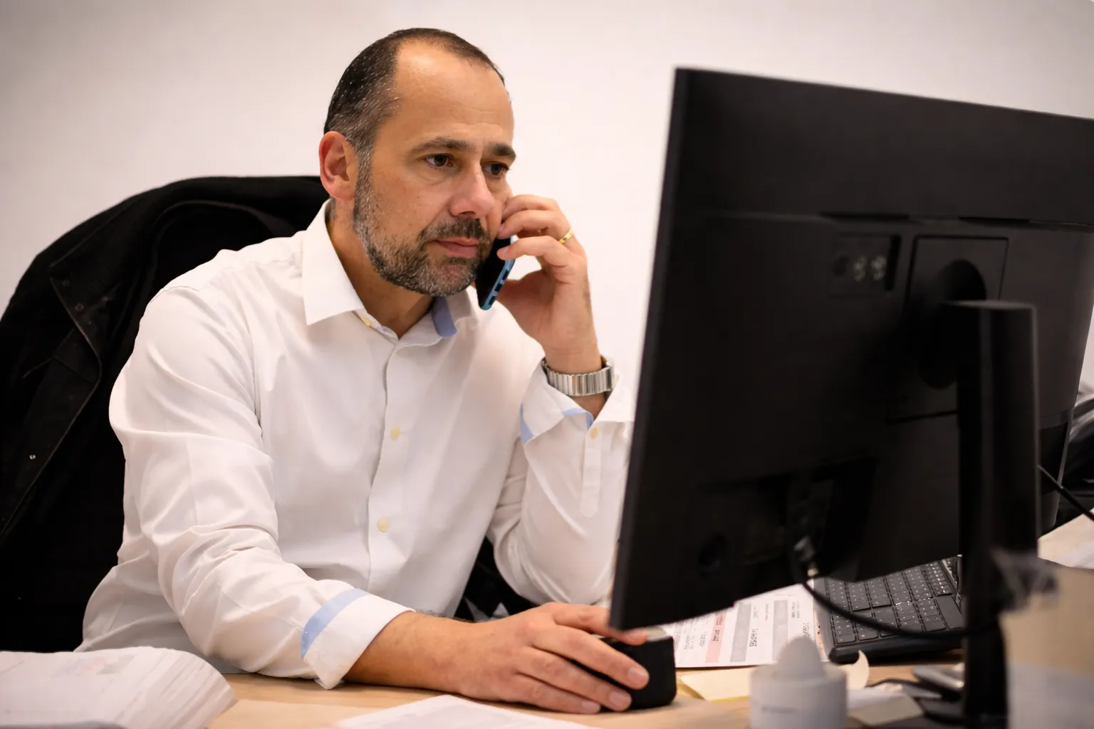 Conseiller en pompes funèbres au téléphone devant son ordinateur au bureau
